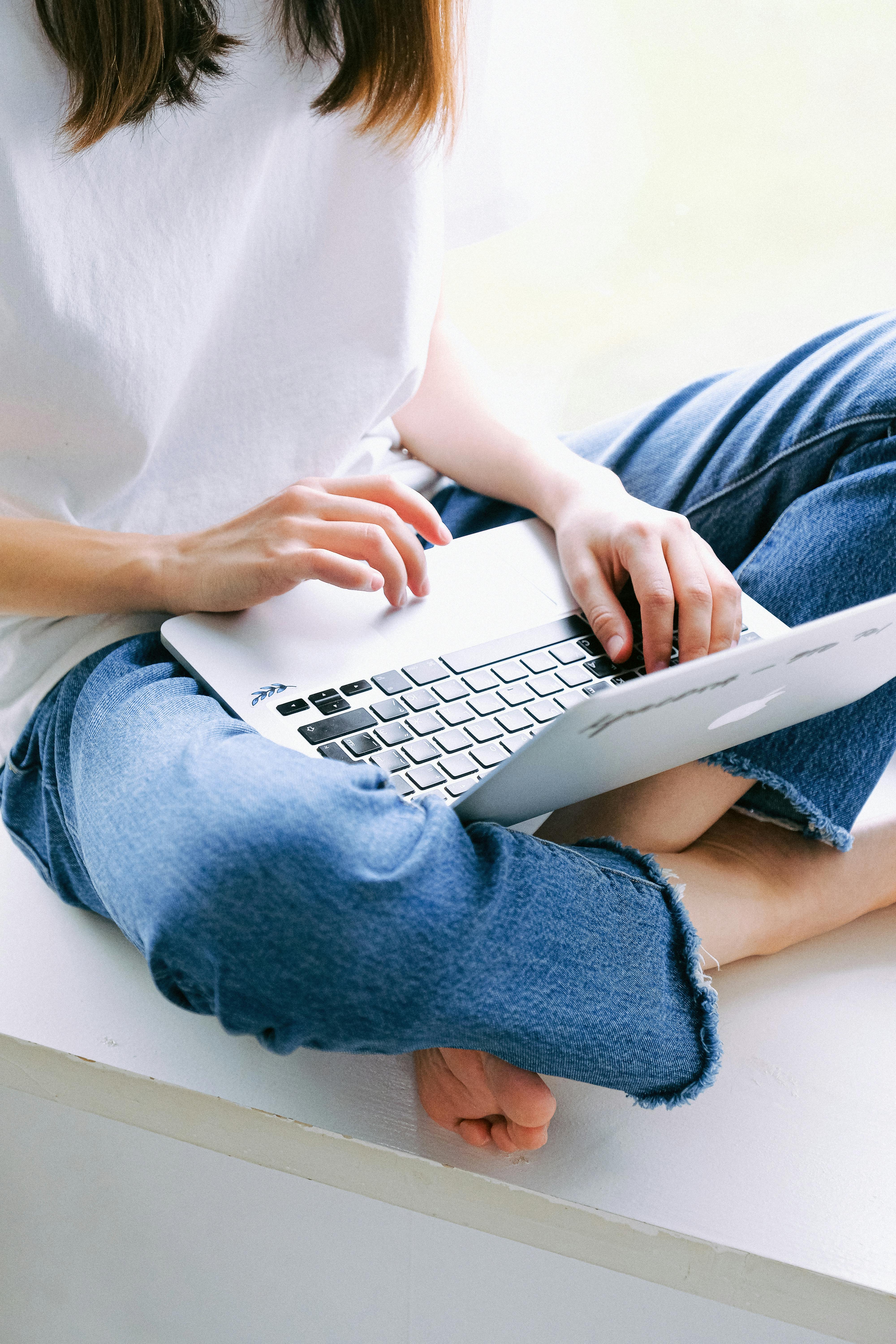 Hands typing on a laptop in a calm, intentional workspace.